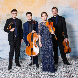 four string quartet musicians white male in glasses holding violin, white male holding a cello, asian femail holding a violin, white male holding a viola