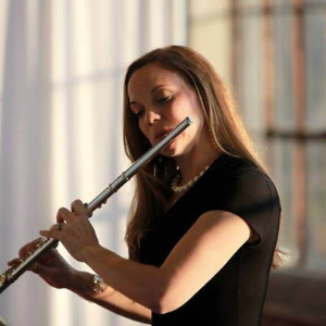 white female with long dark hair flaing a flute