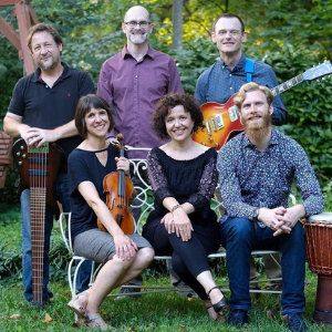 six musicians sitting outside with music instruments