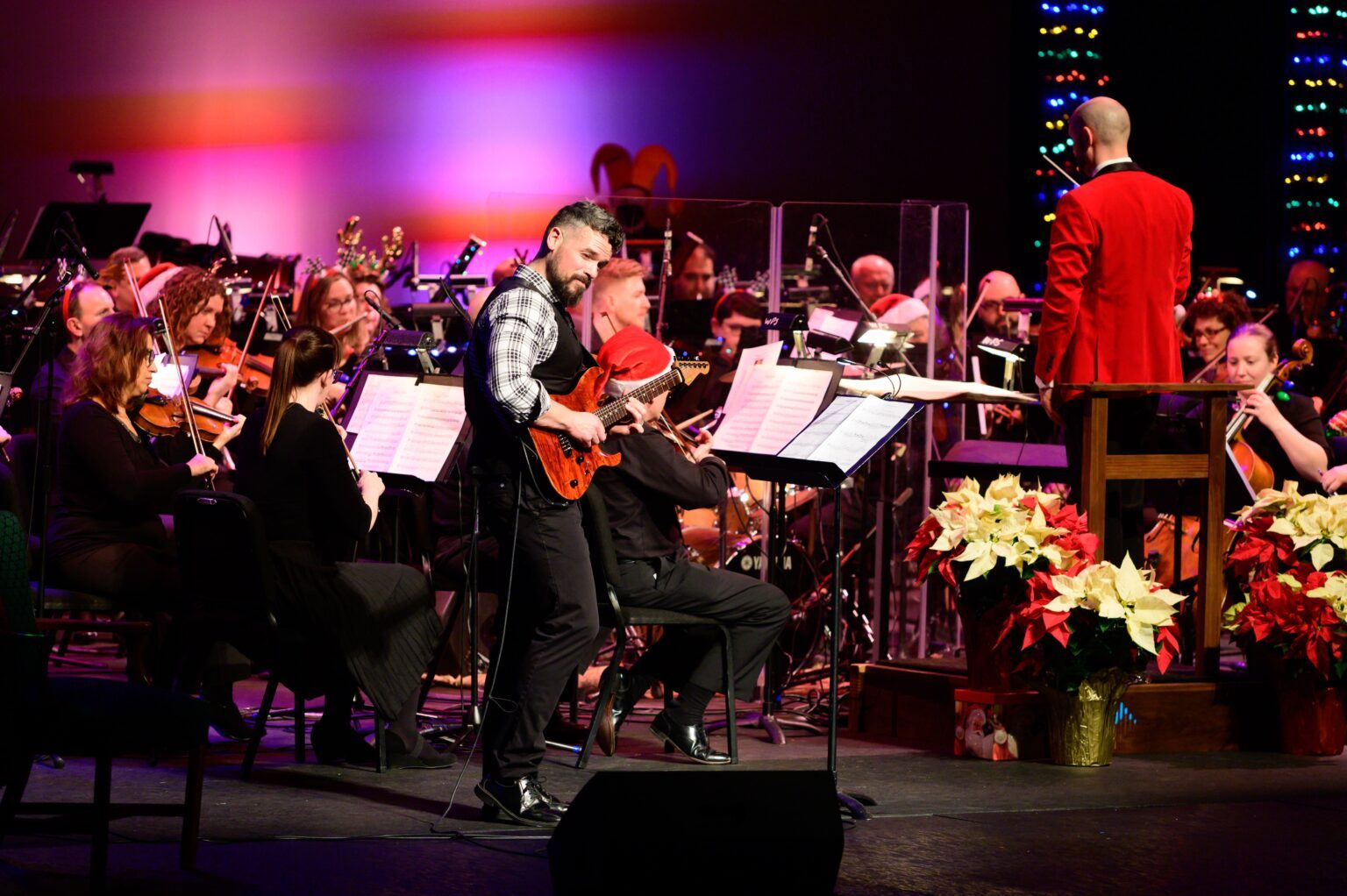 An electric guitar player in front of the Western Piedmont Symphony at the J.E. Broyhill Civic Center at the 2022 Holiday Pops concert