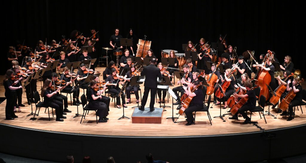 group of young musicians playing orchestra music wearing black clothes
