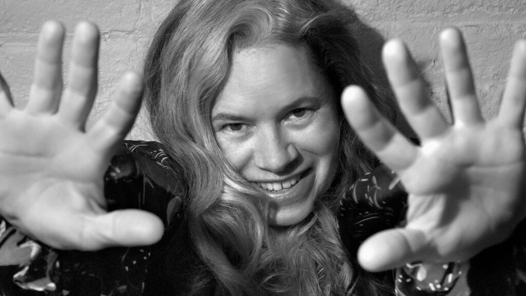 black and white photo of a middle aged white female holding her open hands out to the camera