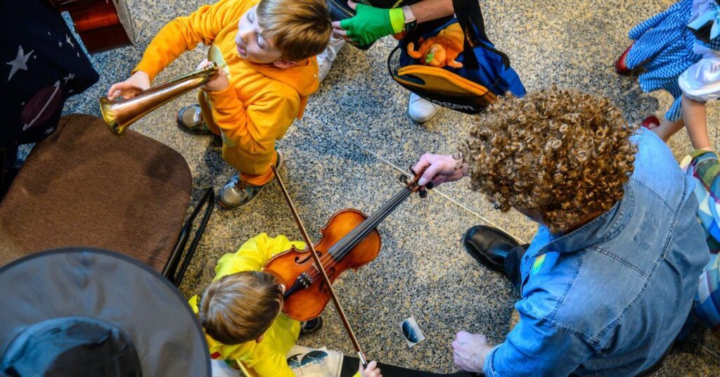 overhead photo of children playing instruments a trumpet and a violin