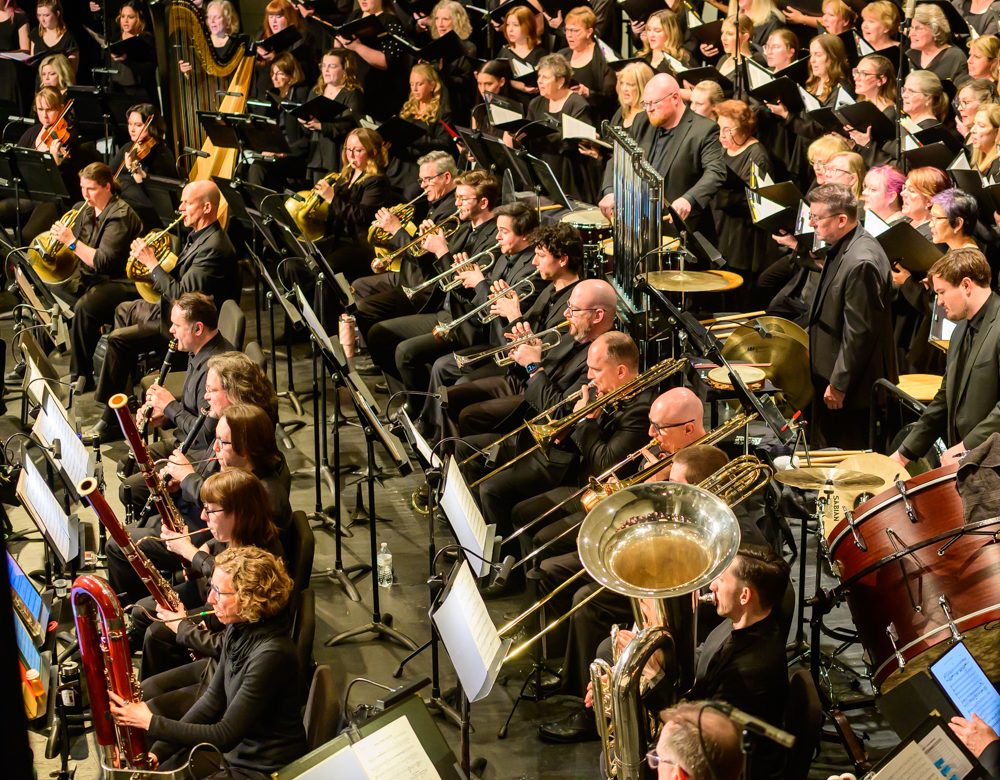 Orchestra brass woodwinds singers percussion in performance